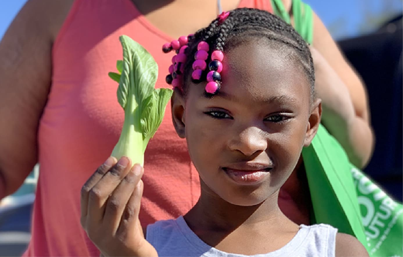 Girl holding up a bok choy