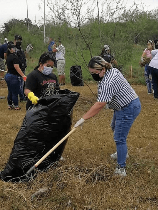 people planting and cleaning up a field