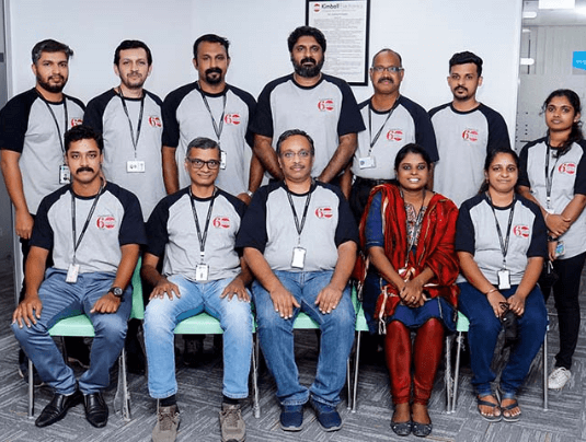 a group of people standing and sitting in a picture pose