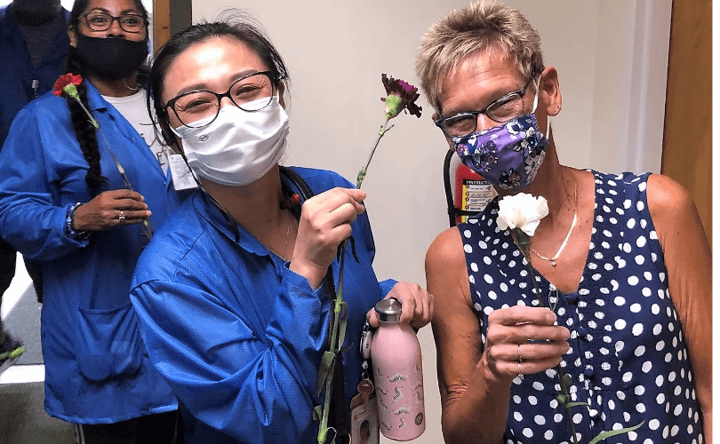 photo of two women holding flowers