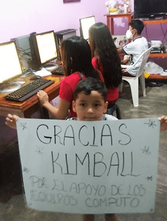 photo of a child holding a sign in spanish saying thank you kimball